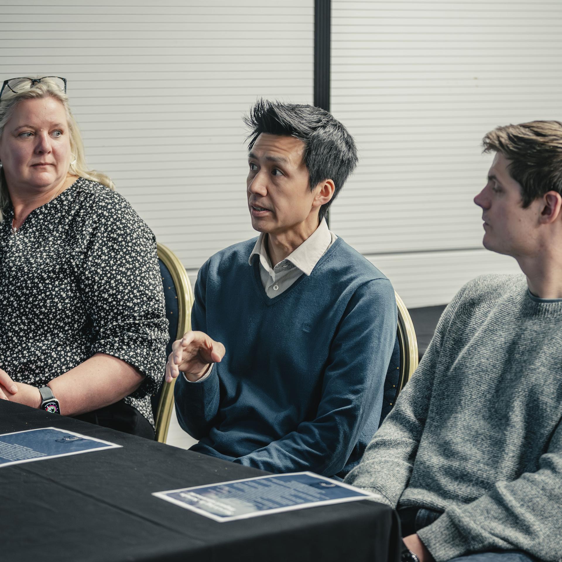 Three delegates sitting at a table 